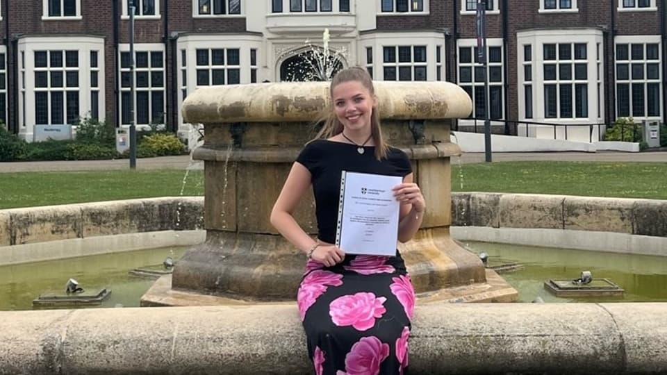 Lily sat in front of a fountain on Loughborough campus